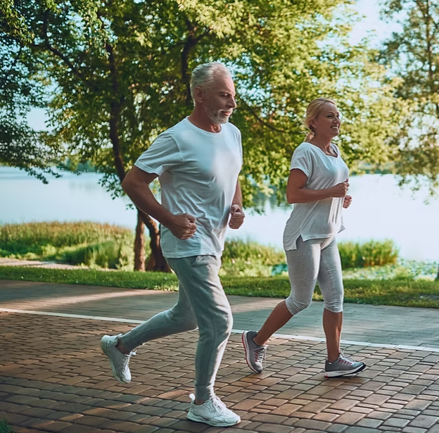 Active couple jogging outdoors by a lake